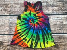 "READY TO SHIP Small Rainbow & Black Spiral Tie Dye Relaxed Fit Racerback Tank This relaxed fit racerback tank is made of premium 100% ringspun cotton. Bottom hem is serger finished. Approximate Measurements (laying flat) Length - 23\" Width (armpit to armpit) - 14.5\" Please refer to the measurements to make sure this item will fit properly. If you need help finding your measurements, measure a tank, that you already love the fit, laying flat from the top to bottom (length) and armpit to armpit Multicolor Vest Tank Top For Festival, Multicolor Racerback Top For Summer, Multicolor Racerback Summer Tops, Fitted Multicolor Racerback Tank Top, Multicolor Racerback Tank Top For Summer, Summer Multicolor Racerback Tank Top, Multicolor Racerback Top For Spring, Spring Festival Racerback Tank Top, Spiral Tie Dye