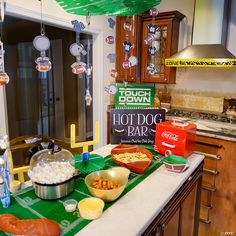 a football themed party with food on the counter and decorations hanging from the ceiling above