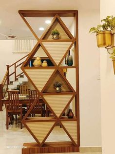 a room divider made out of wood with plants on the top and bottom shelves