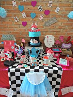 a table topped with lots of cakes and cupcakes next to a brick wall