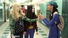 three girls standing in a hallway talking to each other