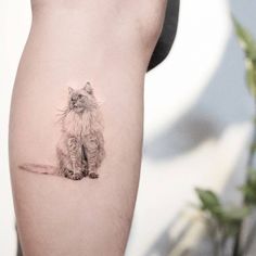 a small cat tattoo on the right side of the leg, it looks like she's sitting down