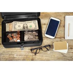 an open briefcase filled with money next to a notepad, pen and eyeglasses