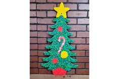 a crocheted christmas tree on a brick wall