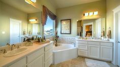 a large bathroom with two sinks and a bathtub