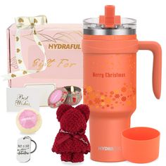 an orange travel mug with a red teddy bear next to it, and other items