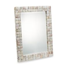 a square mirror made out of white and brown bricks on a white background, with a light reflection in the middle