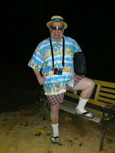 a man in shorts and a hat is sitting on a bench