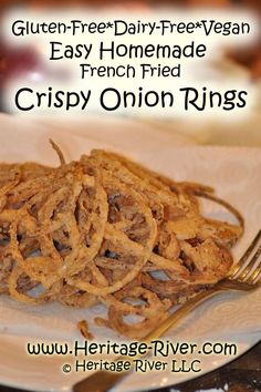 a white plate topped with onion rings on top of a table next to a fork