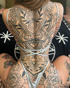 the back of a woman with tattoos on her body