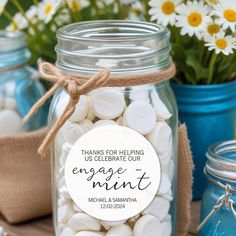 there is a mason jar filled with white buttons and some flowers in the back ground