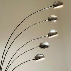 a metal sculpture with five lights hanging from it's sides