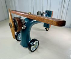 a wooden skateboard sitting on top of a blue wheelbarrow with wheels attached to it