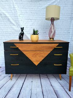 a black and brown dresser sitting on top of a wooden floor