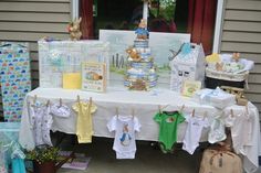 a table that has some baby items on it and is set up outside for sale