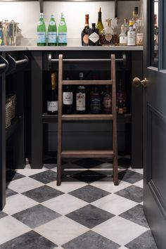 an open cabinet in a kitchen with bottles on the counter