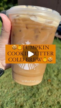 someone holding up a cup of pumpkin cookie butter cold brew