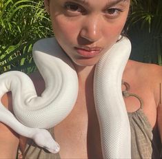 a woman holding a large white snake in her hands