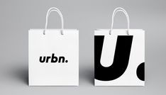 two white bags with black letters on them, one is for u and the other is for u