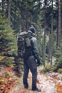 a man with a backpack is walking through the woods