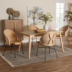 a dining room table with wicker chairs and a bowl of fruit on the table