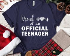 "Proud mom of an Official Teenager shirt, Teenager TShirt, Teenager birthday shirt, Mom of Teenager shirt, Teenager mom gift, Official shirt This comfortable T-shirt is a perfect gift idea as a birthday gift, Christmas Present, or any special occasion for your best friends or your family members or anyone who you love and a really great way of putting a smile on their faces. Retail fit 100% Soft cotton (fibre content may vary for different colors) Light fabric (4.2 oz/yd² (142 g/m Tear away labe Mother's Day Gift Shirt With Funny Text, Funny Text Shirt For Mother's Day Gift, Funny Text Cotton Shirt For Gift, Teenager Birthday, Spanish Shirts, Who You Love, Cheap Shirts, Proud Mom, Love Shirt