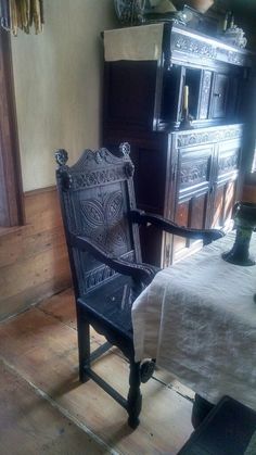 an old chair sitting in front of a wooden dresser