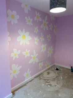 an empty room with pink and white flowers painted on the walls, including a hole in the floor