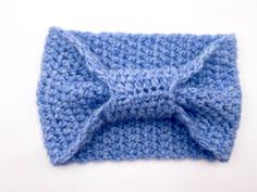 a blue crocheted bow tie on top of a white surface