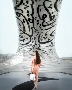 a woman standing in front of a large white structure