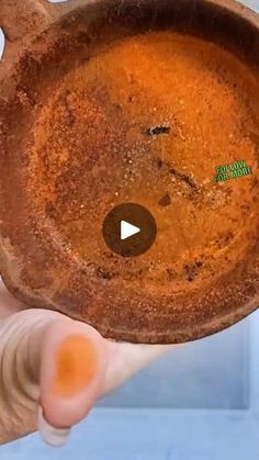 a person holding an old pot with dirt on it's side and a green marker in the middle