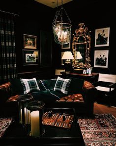 a living room filled with furniture and a chandelier hanging over the top of it