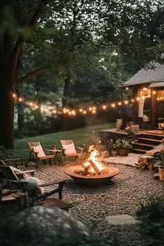 an outdoor fire pit surrounded by chairs and lights