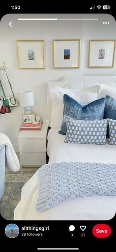 a bed with blue and white pillows in a bedroom next to pictures on the wall