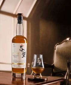 a bottle of whisky sitting on top of a wooden table