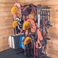 there are many different saddles hanging on the wall