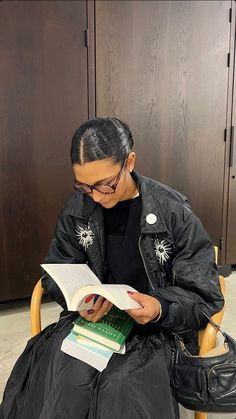 a woman sitting in a chair reading a book