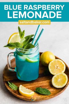 blue raspberry lemonade in a mason jar with mint and lemons on the side