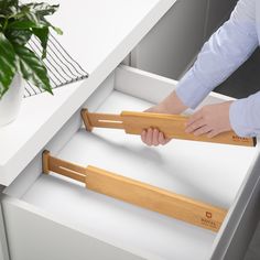 a person is opening the drawer with their hand and holding it up to pull out