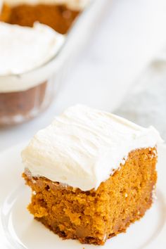 a piece of cake sitting on top of a white plate next to a glass dish