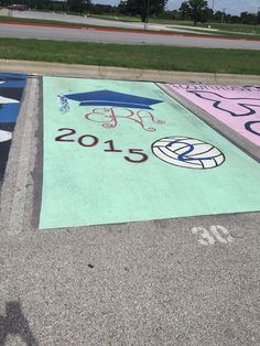 an empty parking lot with painted numbers and symbols on the ground in front of a street