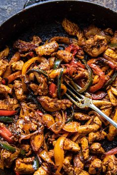 a skillet filled with chicken and peppers