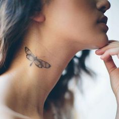 a woman with a butterfly tattoo on her neck