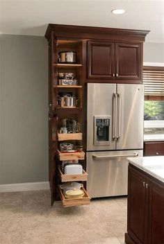 a kitchen with brown cabinets and stainless steel refrigerator freezer next to an open drawer