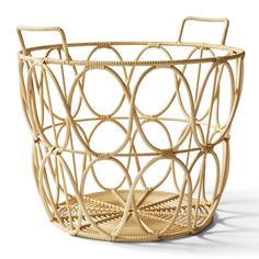 a wicker basket with handles and circles on it's sides, sitting on a white surface