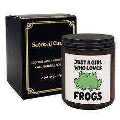 a candle that is next to a box with a frog on it's side