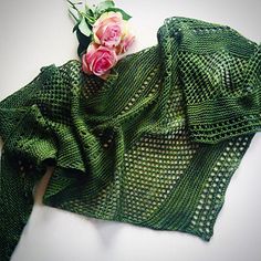 a green shawl with flowers on top of it