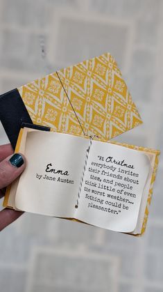 a person holding an open book in their left hand with writing on the front and back