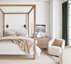 a bedroom with a four poster bed and white walls