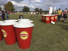 people are standing around with red cups on the grass